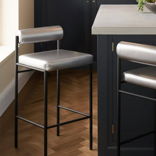 A leopard print sofa bed styled in a room in front of a dark wall with various home accessories.
