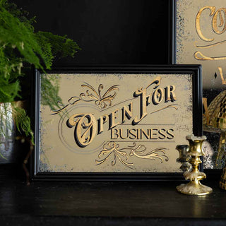 A vintage style rectangular mirror on a sideboard that says 'open for business'.