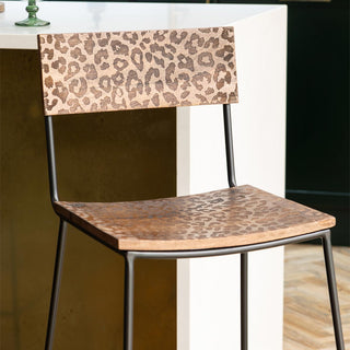 Two black and pink bar stools styled next to a kitchen island.