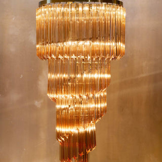 The Champagne Large Cabaret Chandelier displayed illuminated in front of a neutral wall.