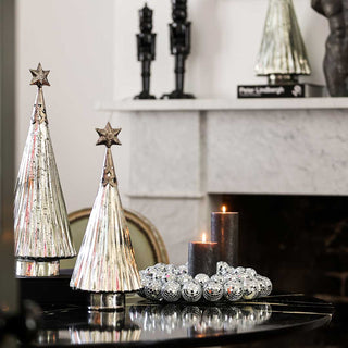 Silver christmas tree decoration styled on a coffee table.