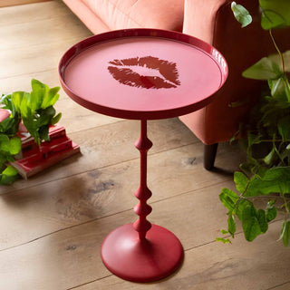 A very quirky tortoise side table with a glass and candles styled on it