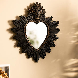 A decorative rectangular mirror with the words 'Fortune Telling/You're Fucked', styled on a wall above various home accessories.