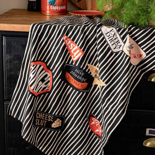 Various slogan serving boards styled with food and kitchen accessories in front of a black wall.