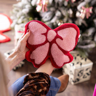 Two floral vases displayed on a table with some greenery.