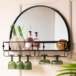 A black mirror with bar shelf, styled on the wall with various accessories.