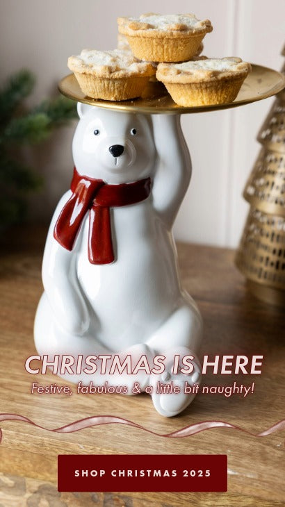 Ceramic polar bear with a tray of pies on a wooden surface, with text promoting Christmas shopping.