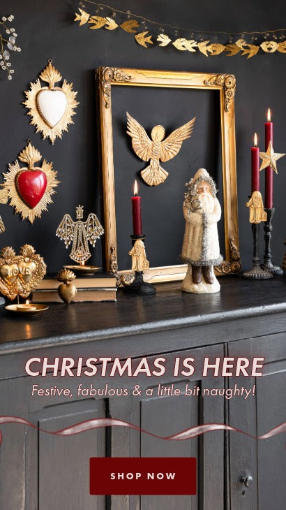 Decorative Christmas display with candles, figurines, and text on a dark surface.