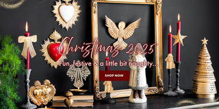 A Christmas image channelling 'vintage Christmas' vibes - black and antiqued gold hearts, candle holders and Christmas trees.