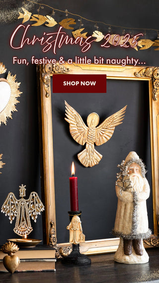A festive tableau featuring a kitsch Santa, jewelled angel candle holder and ornate gold mirror frame.