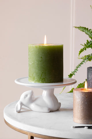 lifestyle image of lazy rabbit cupcake plate on a light background with a candle on top