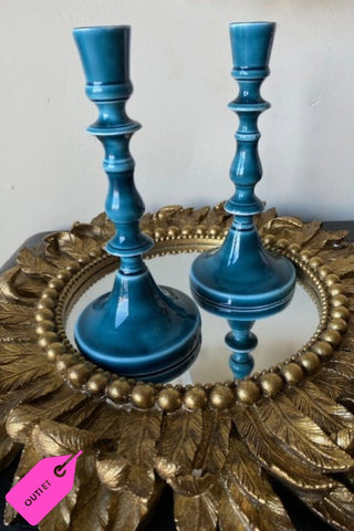 Lifestyle image of the Pair of Deep Blue Enamel Cast Style Candlestick Holders set on a gold mirrored tray with a white background.