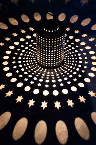 The Black Star Solar Light displayed illuminated, casting light patterns onto the floor.