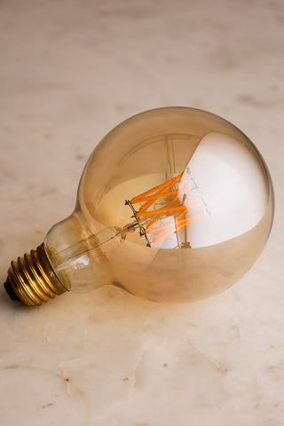 Image of the Globe E27 6W Amber LED Light Bulb on a white surface. 