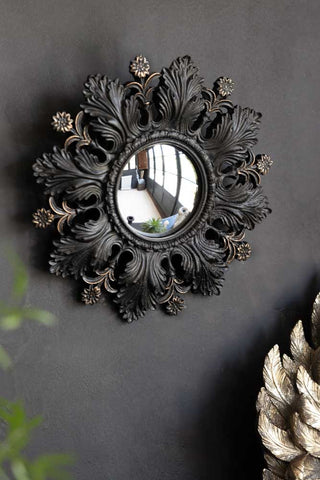 Lifestyle image of small black flowers leaves convex mirror.