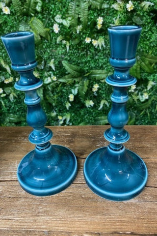Image of the Pair of Deep Blue Enamel Cast Style Candlestick Holders on a wooden surface.