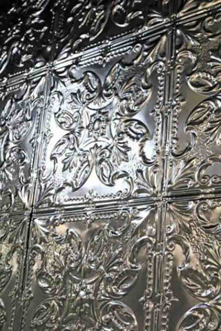 Close up image of silver Rockett St George tin tiles in a floral pattern. 