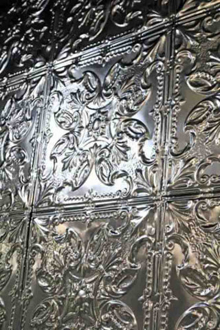 Close up image of silver Rockett St George tin tiles in a floral pattern.