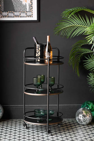 The Antiqued-Style 3 Tier Metal Drinks Trolley styled with bottles of wine and glasses.