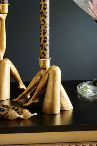 Sexy Gold Legs Candle Holder on a black sideboard with leopard print candles.
