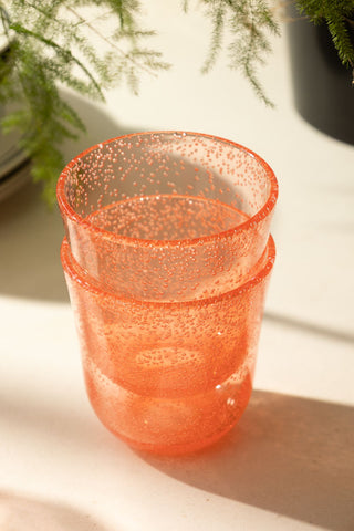 An image of two acrylic coral pink picnic glasses stacked on top of eachother.