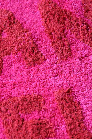 Close-up image of the And Relax Hot Pink Tufted Bath Mat