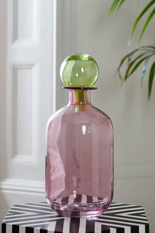 A styled image of the Pink & Green Apothecary Bottle on a monochrome side table.
