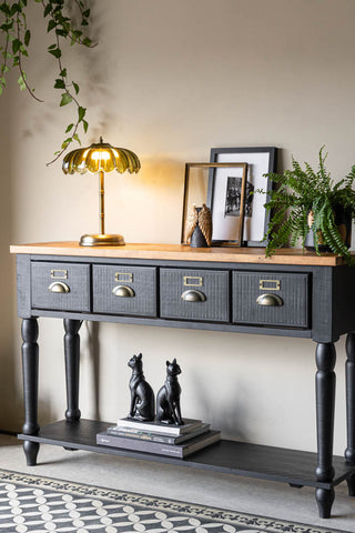 A styled image of the Apothecary Console Table with a table lamp and plant on it.