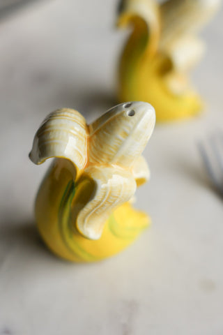 Detail image of the Banana Salt & Pepper Shakers displayed on a table.