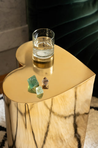 The Beautiful Brass Heart Side Table with a glass of water and some crystals on.