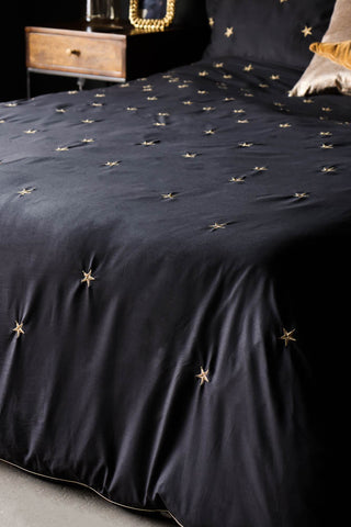 Detail image of the Black Falling Star Duvet Cover and Pillow Case Set styled on a bed. 
