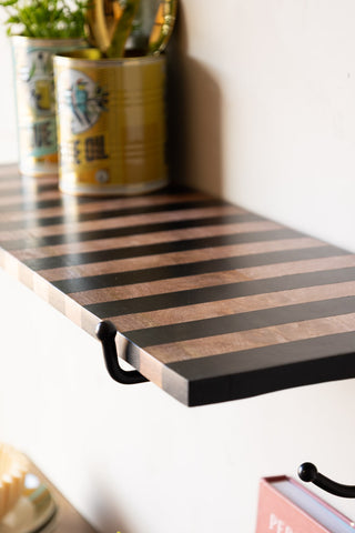 Close-up of the Black Stripe Wooden Shelf With Bracket styled with metal storage tins on.