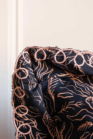 Detail shot of the corner of the Black & Pink Tiger Cushion With Pretty Scalloped Edge.