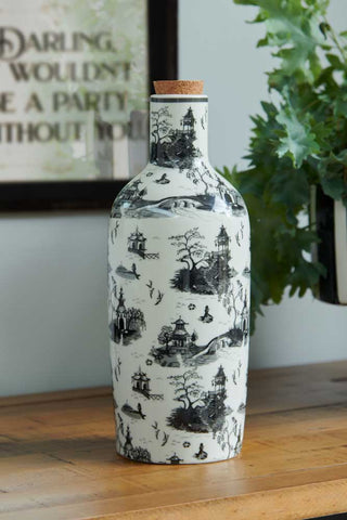 Lifestyle image of the Black & White Willow Toile Bottle Vase on a wood surface