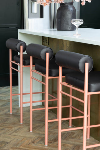 Three of the Black and Pink Roll Back Bar Stools styled at a kitchen island.