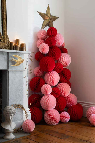 Red and pink honeycomb ball tree on a wooden trellis with a gold star at the top.