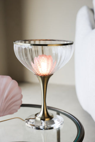 Cocktail table lamp on a side table lit styled next to pink accessories.