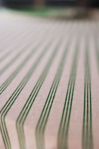 Image of the material for the Cotton Green Stripe Table Cloth with Orange Pom-Poms