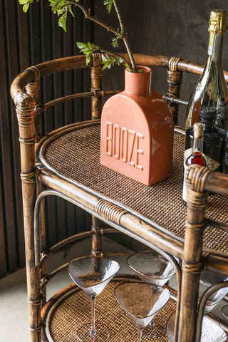 Close-up image of the Dark Brown Rattan Console/Drinks Table styled with bar accessories.