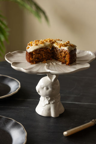 Lifestyle image of the Decorative Rabbit Cake Plate on a black dining table styled with black side plates.