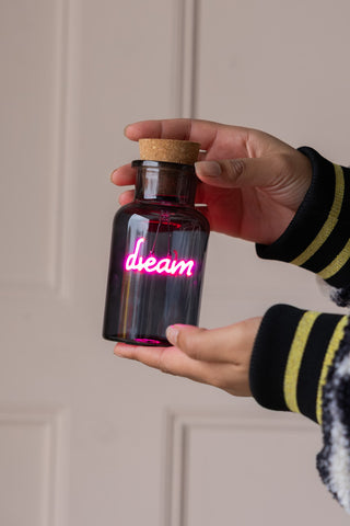 The Dream Neon Bottle Light being held in a model's hands.