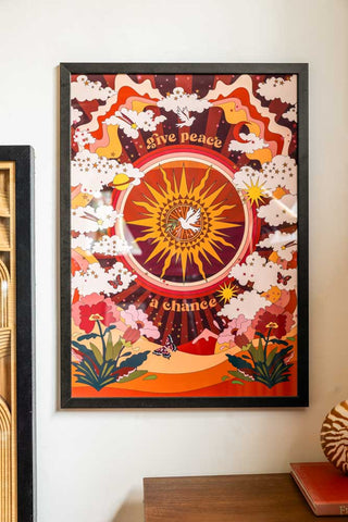 Lifestyle image of the Give Peace A Chance A2 Art Print in a black frame  on a light background