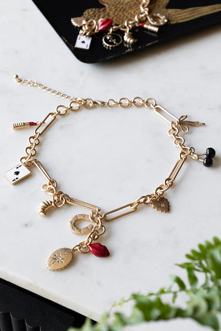 The Gold Chunky Chain Charm Necklace on a table with some other jewellery in a trinket tray.