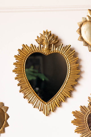 The Gold Sacred Heart Ornate Mirror on a wall with other gold frame mirrors.