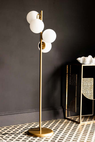 Lifestyle image of the Gold & White Opaque Globe Floor Lamp. 