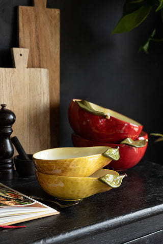 A lifestyle image showing two of the Golden Pear Snack/Serving Bowls styled in a cosy dark kitchen