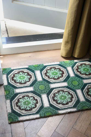 The Green Florentine Patterned Doormat by an open door.