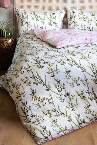 The Green & Pink Bamboo Print Reversible Duvet Cover and Pillow Case Set styled on a bed, showing both sides of the design.