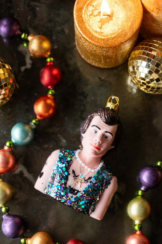 Harry Inspired Christmas Decoration on glass table with multicoloured garland and candle flat lay