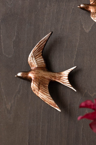 Lifestyle image of the Large Antiqued Copper Swallow Wall Decoration